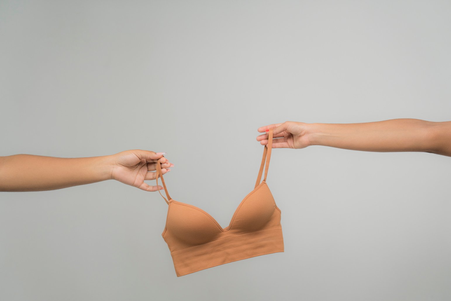 People Holding a Skin Tone Brassiere